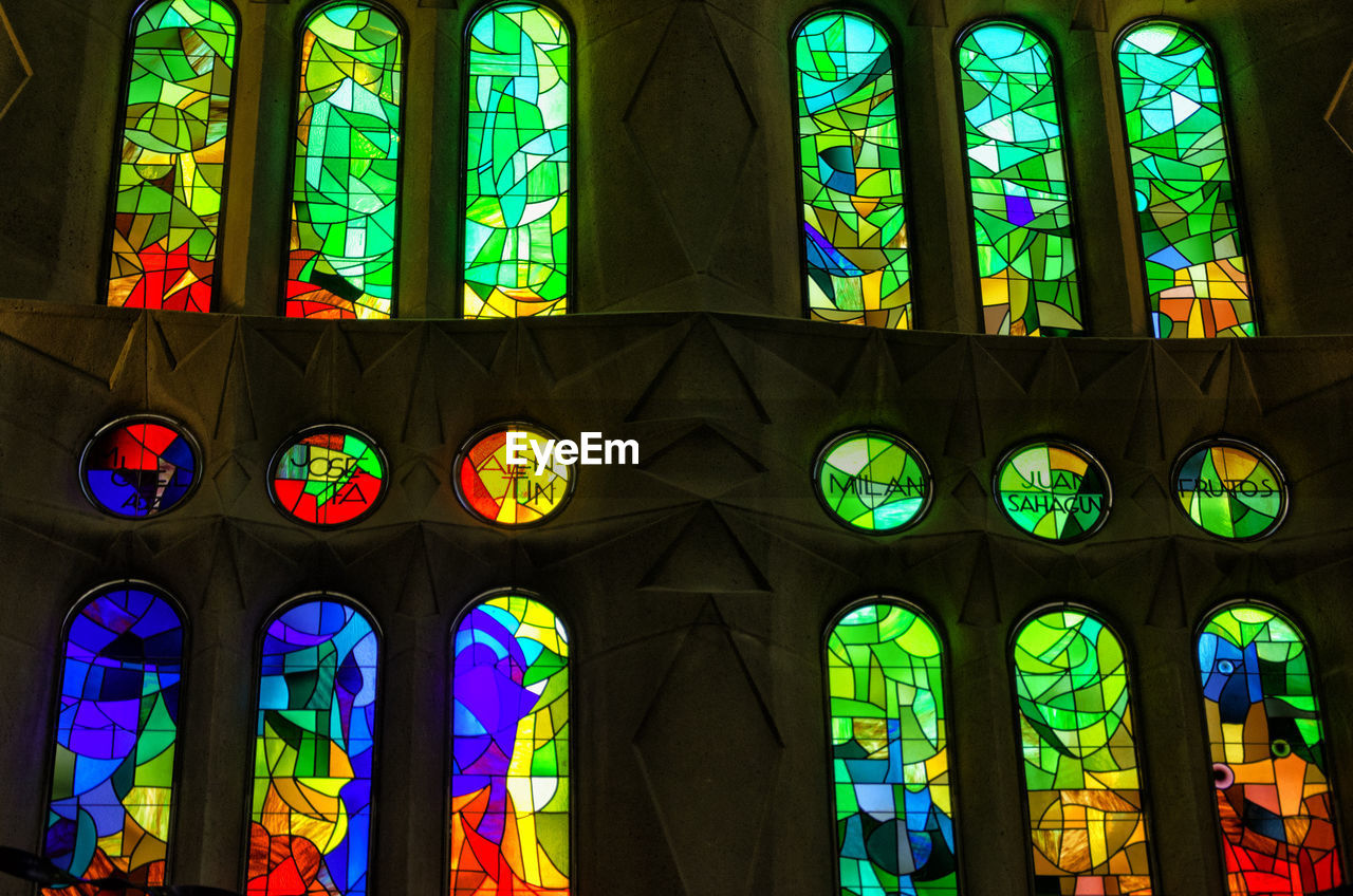 LOW ANGLE VIEW OF ILLUMINATED GLASS WINDOW OF BUILDING