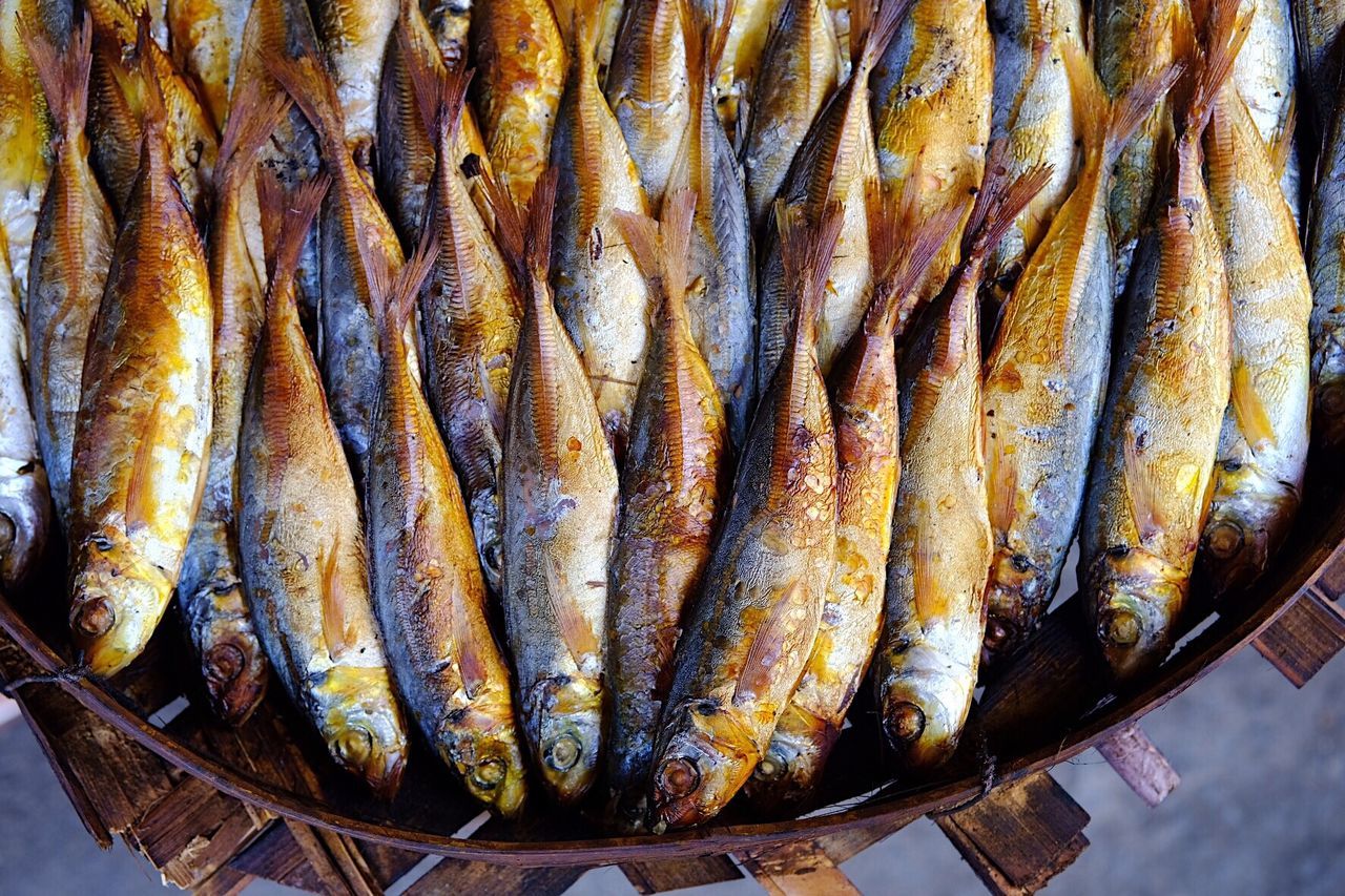 Grilled fishes in bowl at market for sale