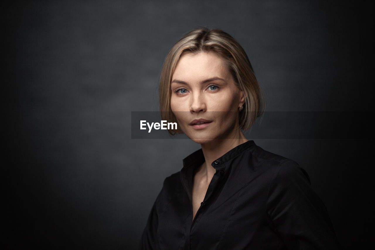 Portrait of beautiful young woman over black background