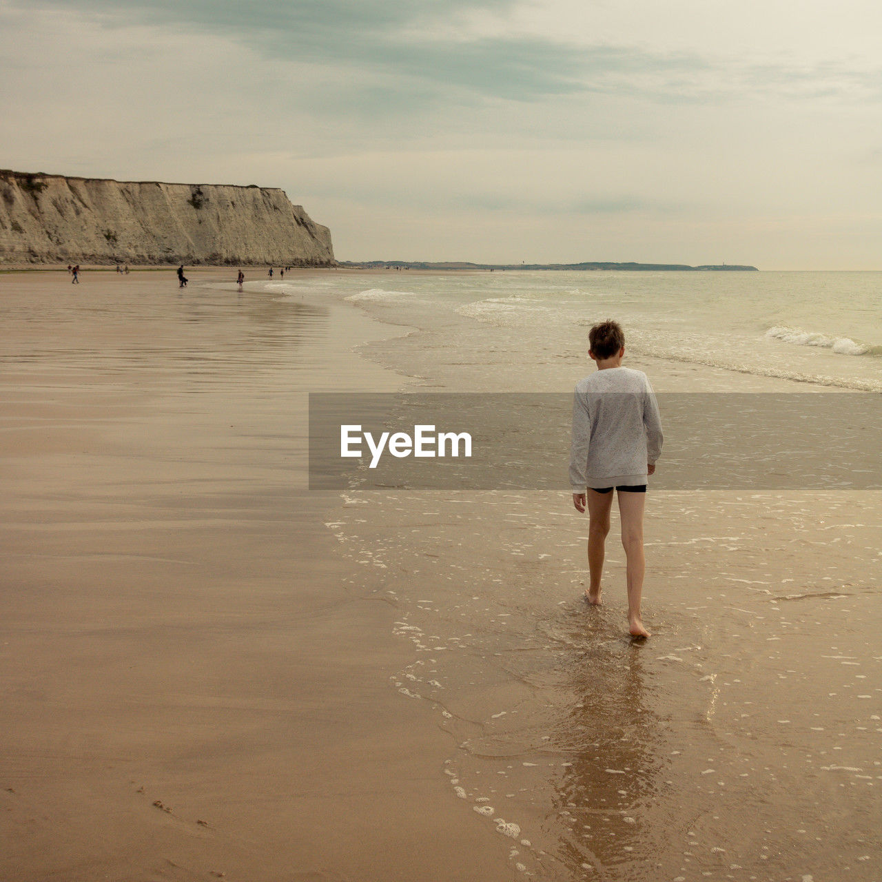 rear view of woman walking at beach