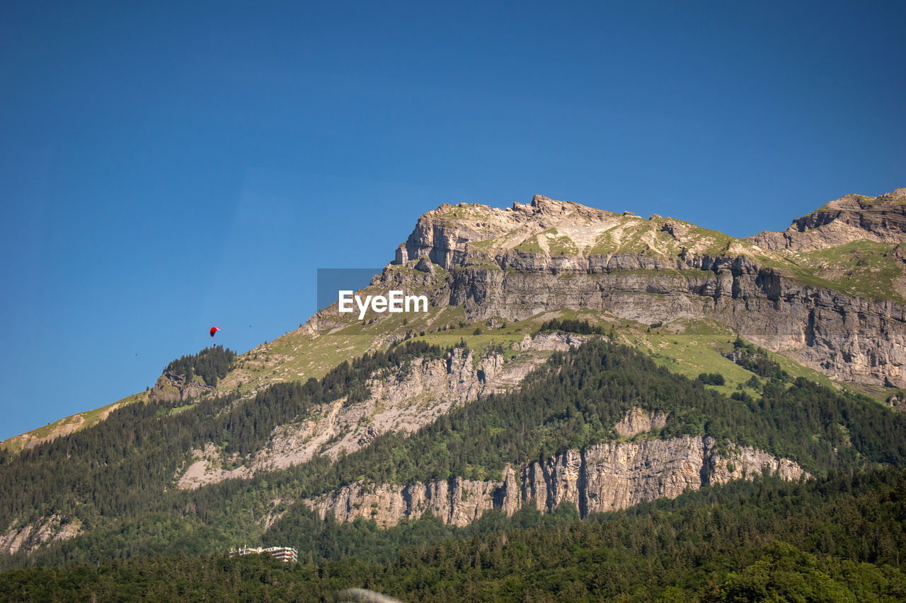 mountain, sky, scenics - nature, nature, land, landscape, environment, travel, travel destinations, clear sky, blue, plant, beauty in nature, mountain range, tree, tourism, leisure activity, rock, sunny, outdoors, non-urban scene, architecture, forest, day, activity, plateau, pinaceae, hiking, tranquility, trip, vacation, coniferous tree, holiday, tranquil scene, pine tree, adventure, cliff, mountain peak, sunlight, ridge