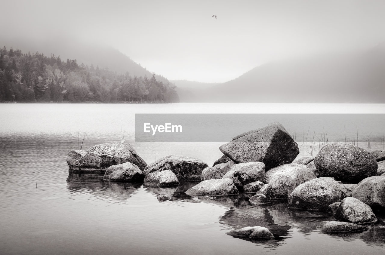 Scenic view of lake against sky during foggy weather