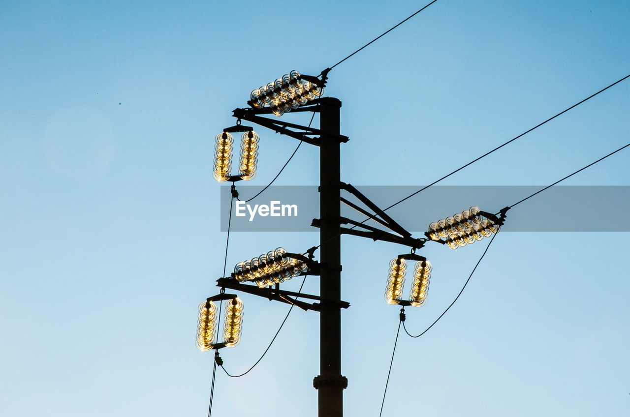 LOW ANGLE VIEW OF CRANES AGAINST CLEAR BLUE SKY