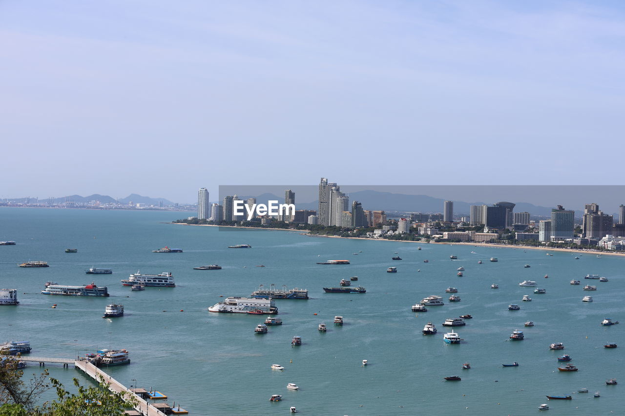 High angle view of city by sea against sky