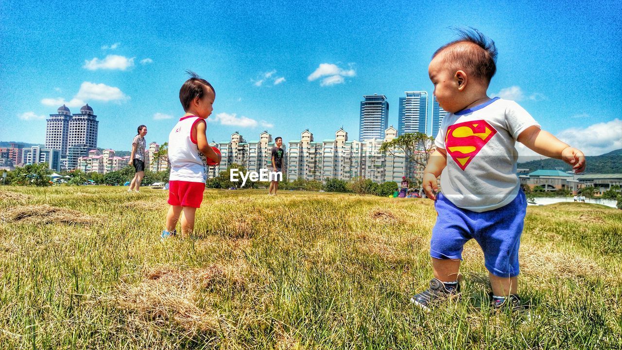 LITTLE GIRL PLAYING ON GRASSY FIELD