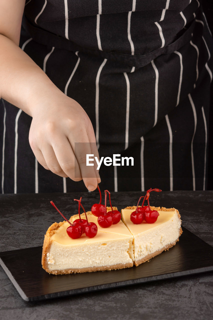 The chef decorates a classic cheesecake with cherry berries