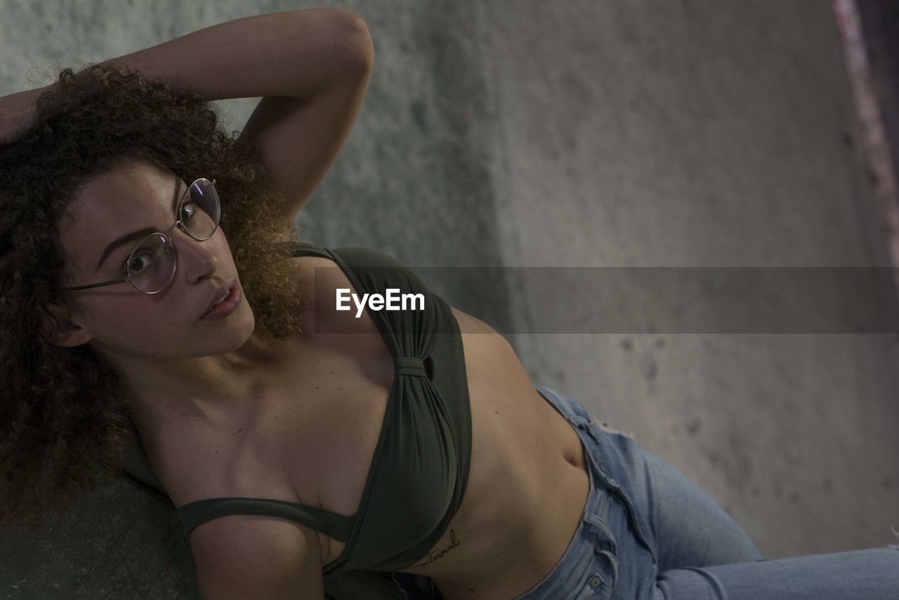 High angle portrait of young woman against wall
