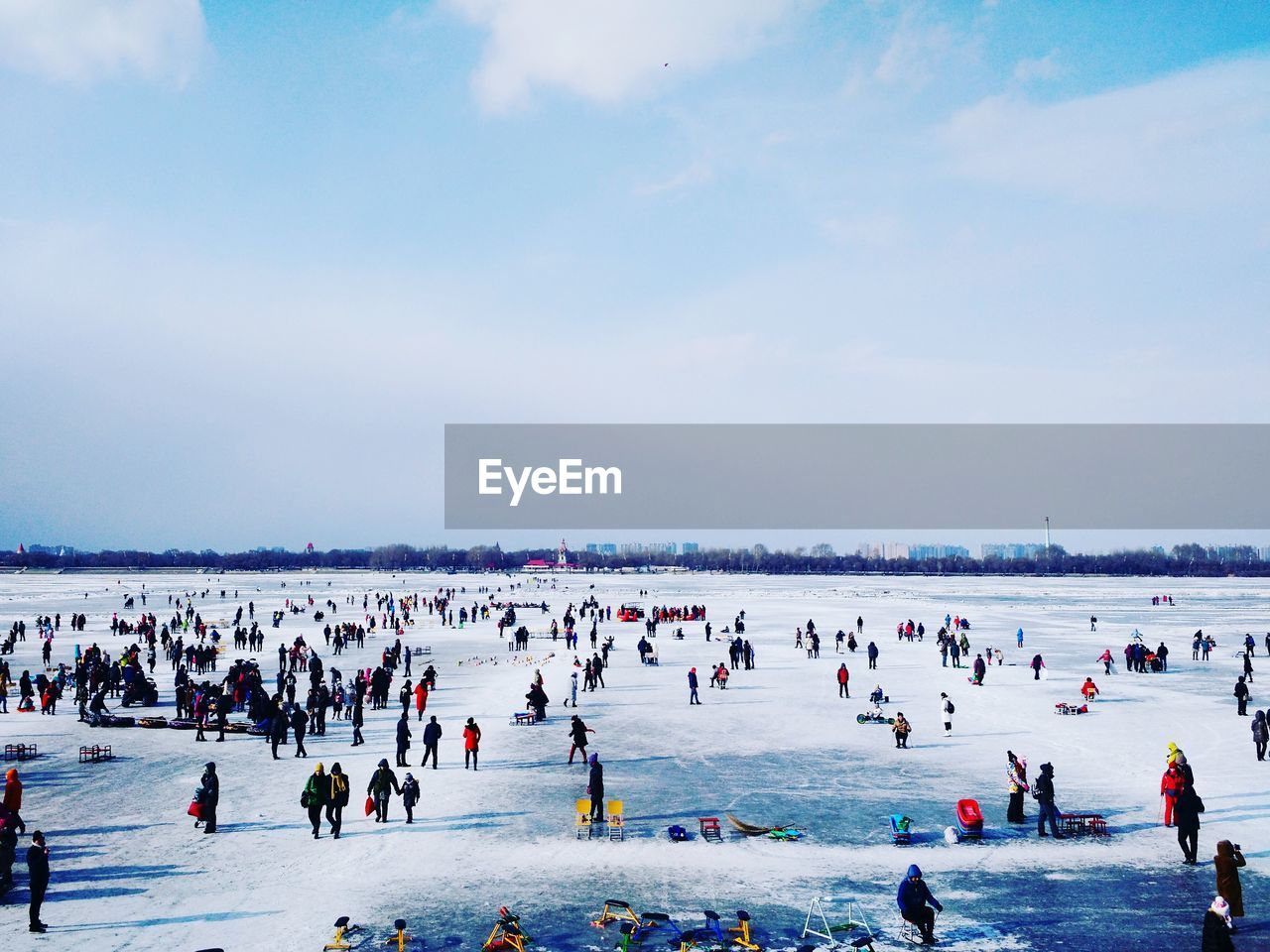 People at frozen songhua river against cloudy sky