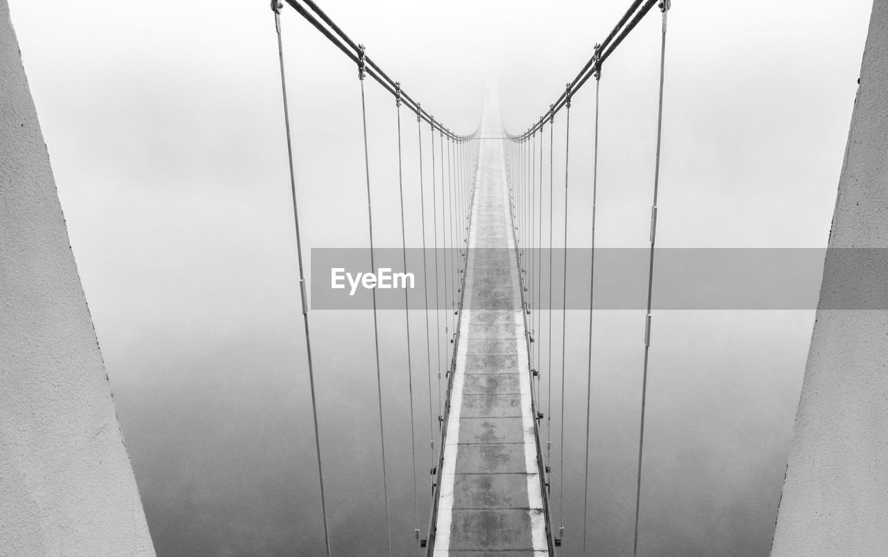 black and white, architecture, line, built structure, fog, bridge, monochrome, suspension bridge, monochrome photography, white, transportation, engineering, the way forward, nature, sky, steel cable, day, outdoors, city, diminishing perspective, cable-stayed bridge, metal, travel, cable