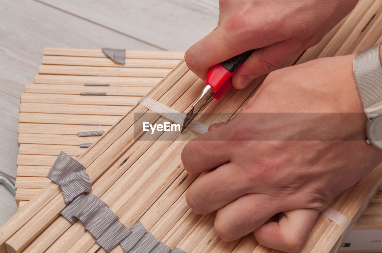 CLOSE-UP OF WOMAN HAND ON WOODEN TABLE