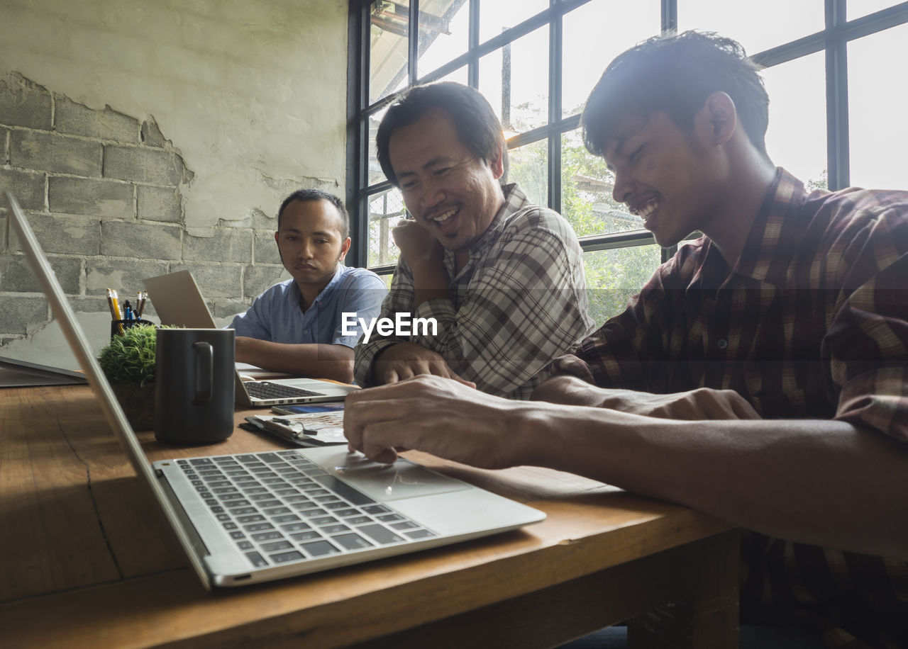 Business colleagues discussing over laptop in office