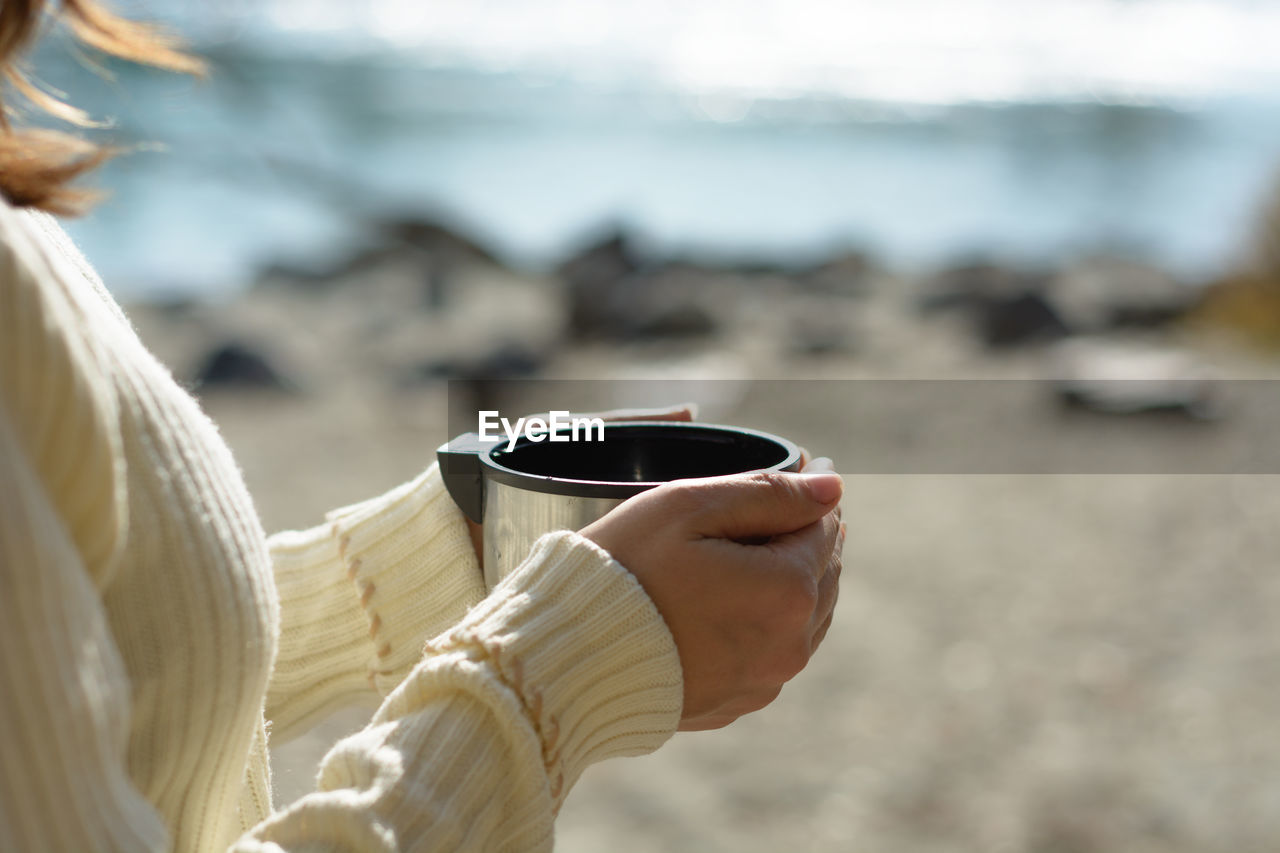 Close-up of hand holding coffee cup