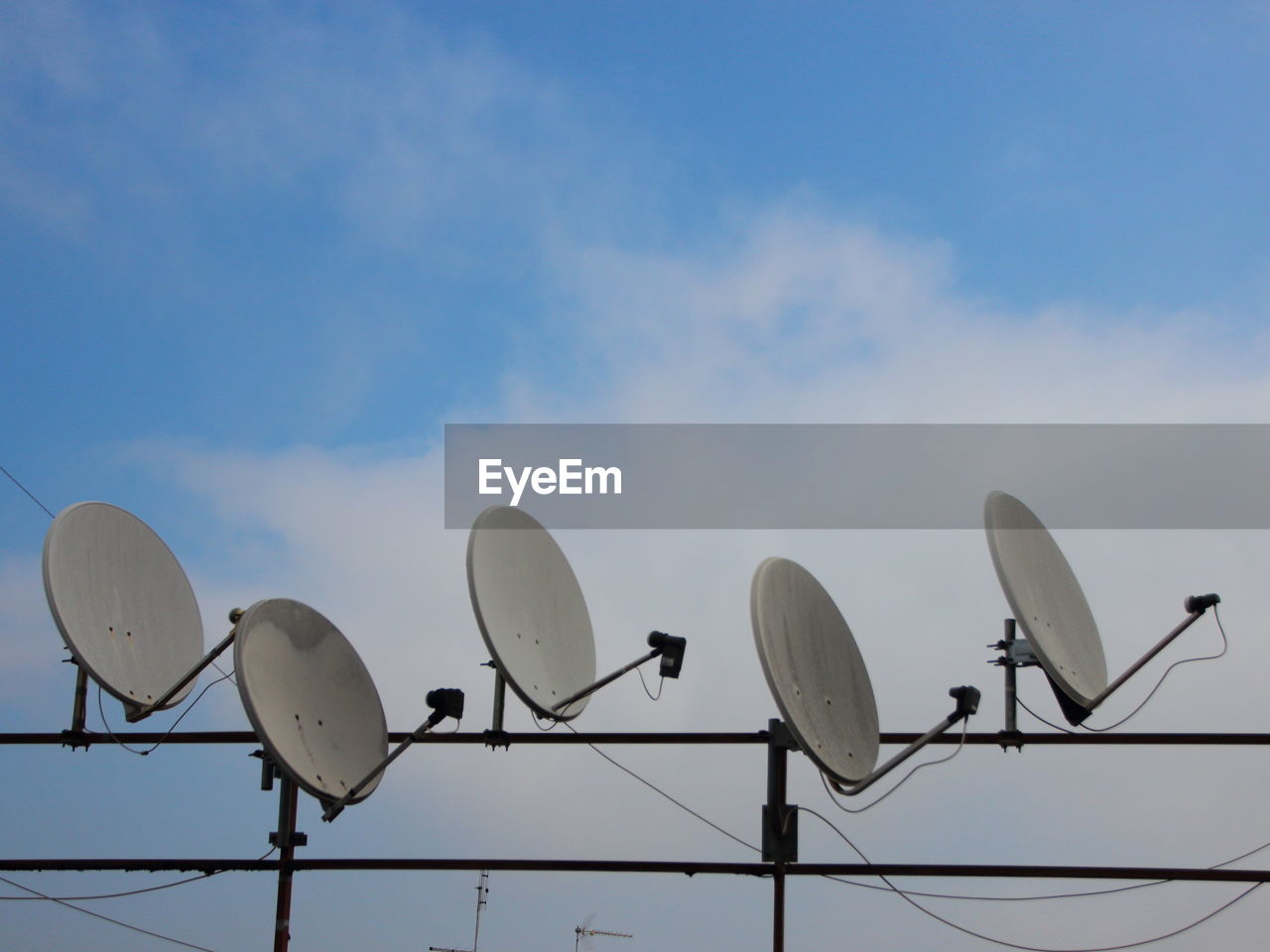 Low angle view of satellite dishes against sky