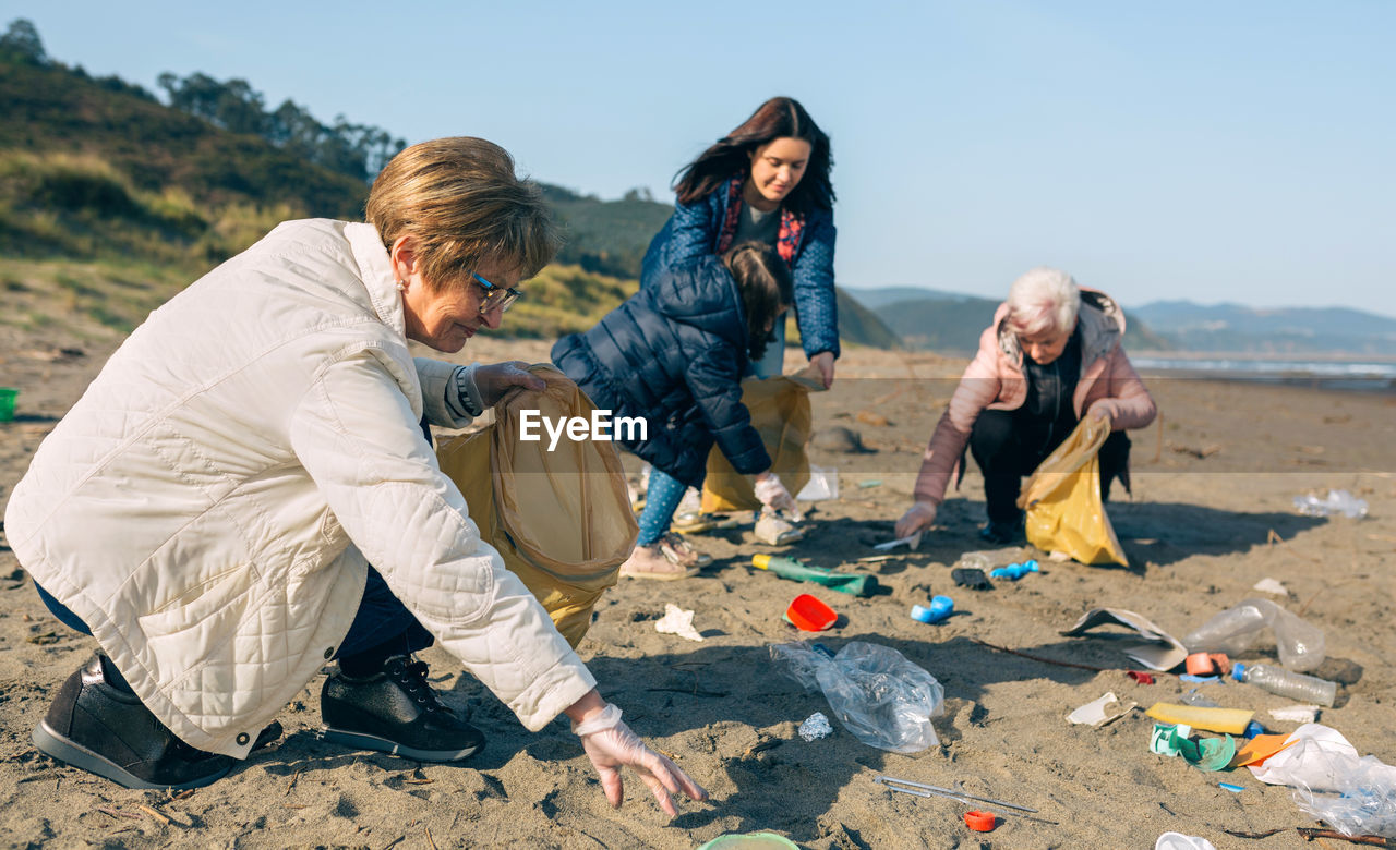 Family picking garbage at beach