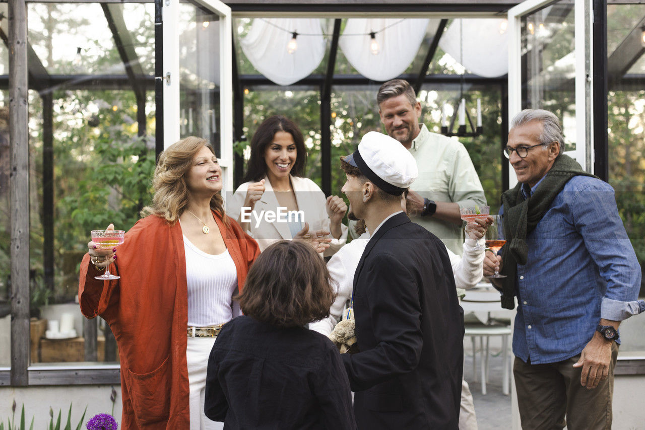 Happy family welcoming young man at summer party