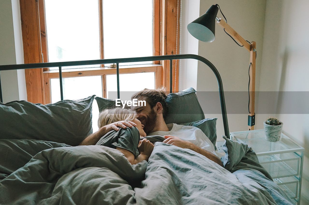 Young couple relaxing on bed at home