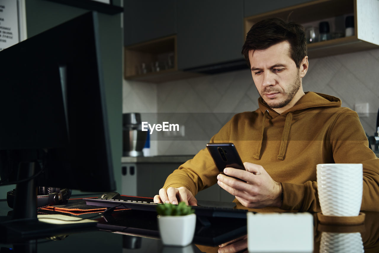 Man working at home office and use smartphone