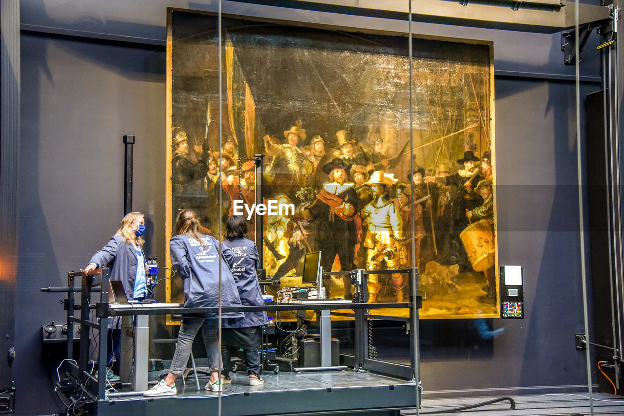 GROUP OF PEOPLE WORKING IN GLASS WINDOW