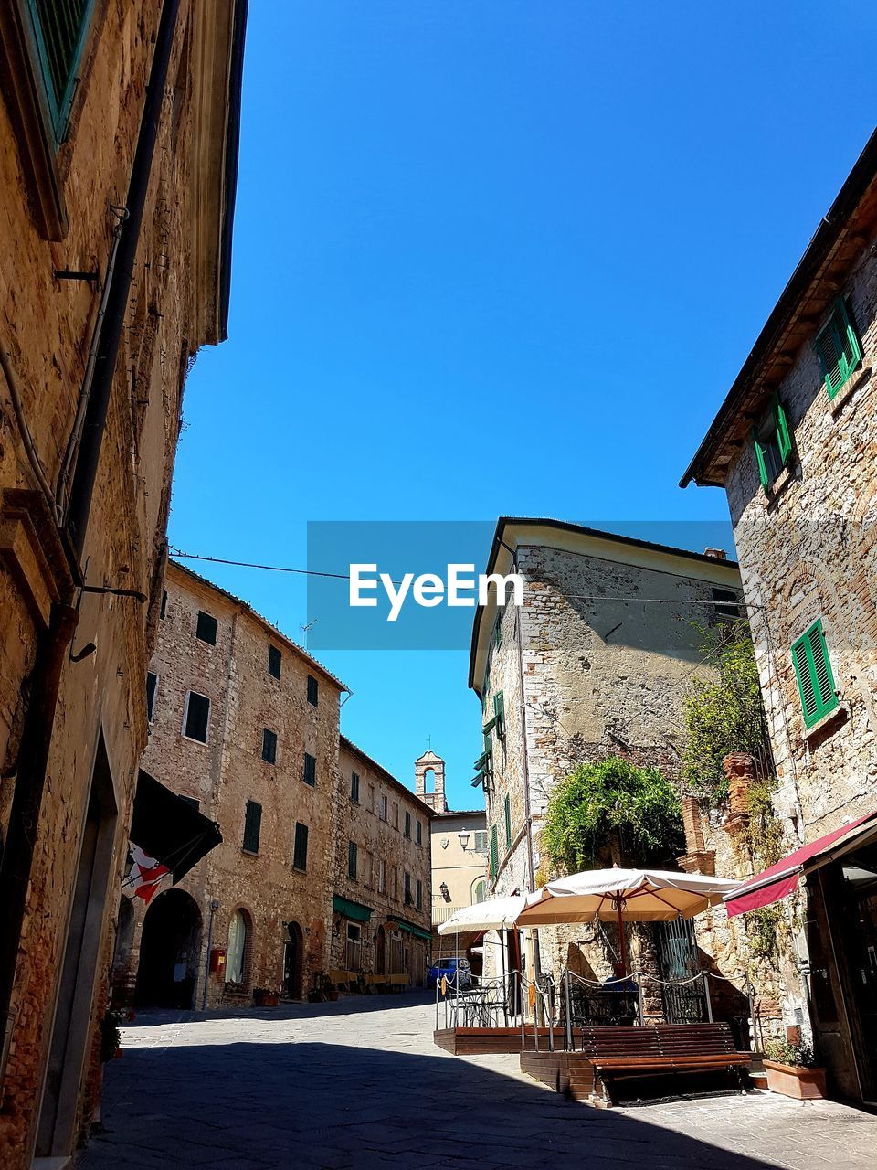 Low angle view of buildings against clear blue sky in city