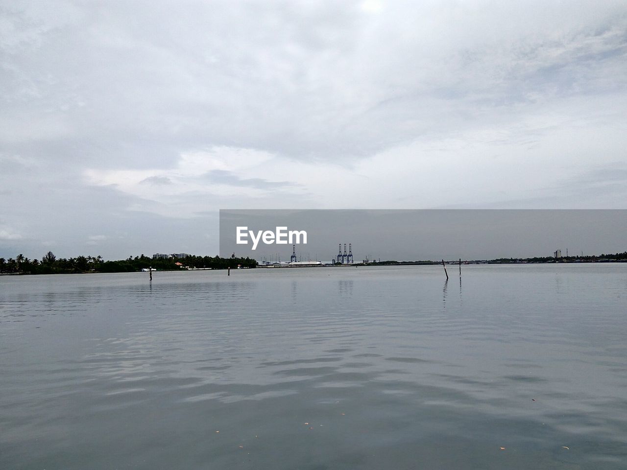 Scenic view of river against cloudy sky