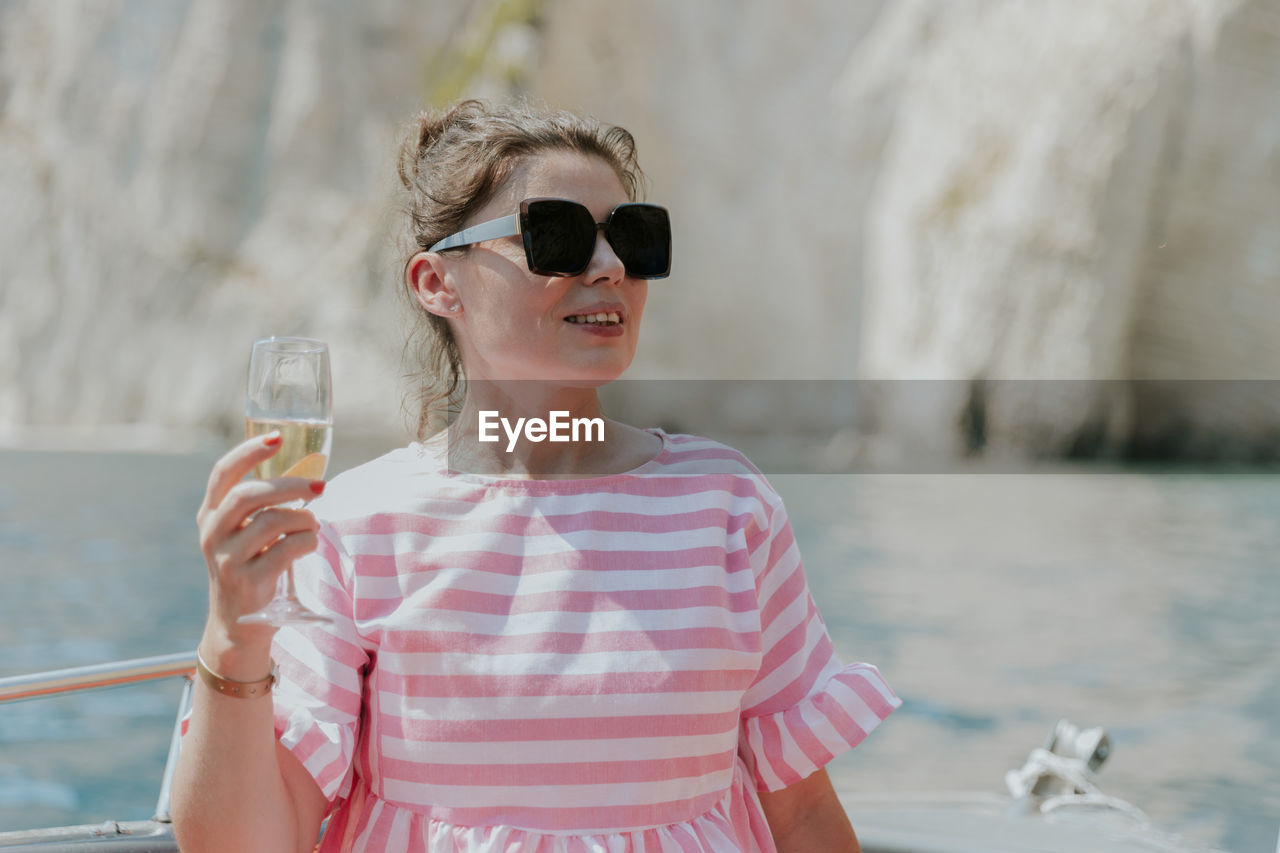 Portrait of a young girl drinking champagne in a boat.