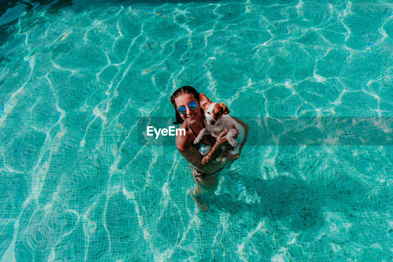 High angle view of woman with dog swimming in pool
