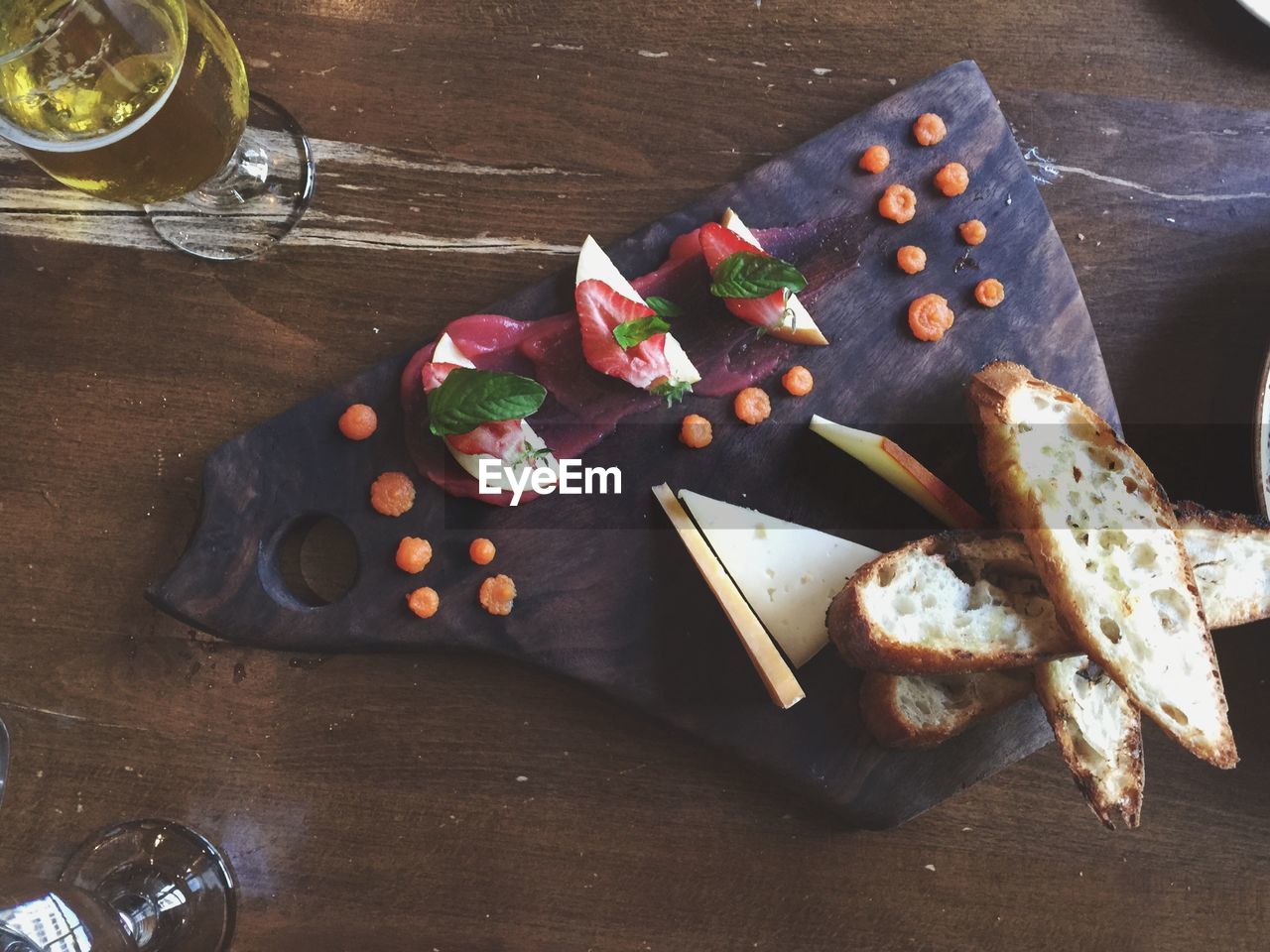 Beer glass with fruit and bread on tray