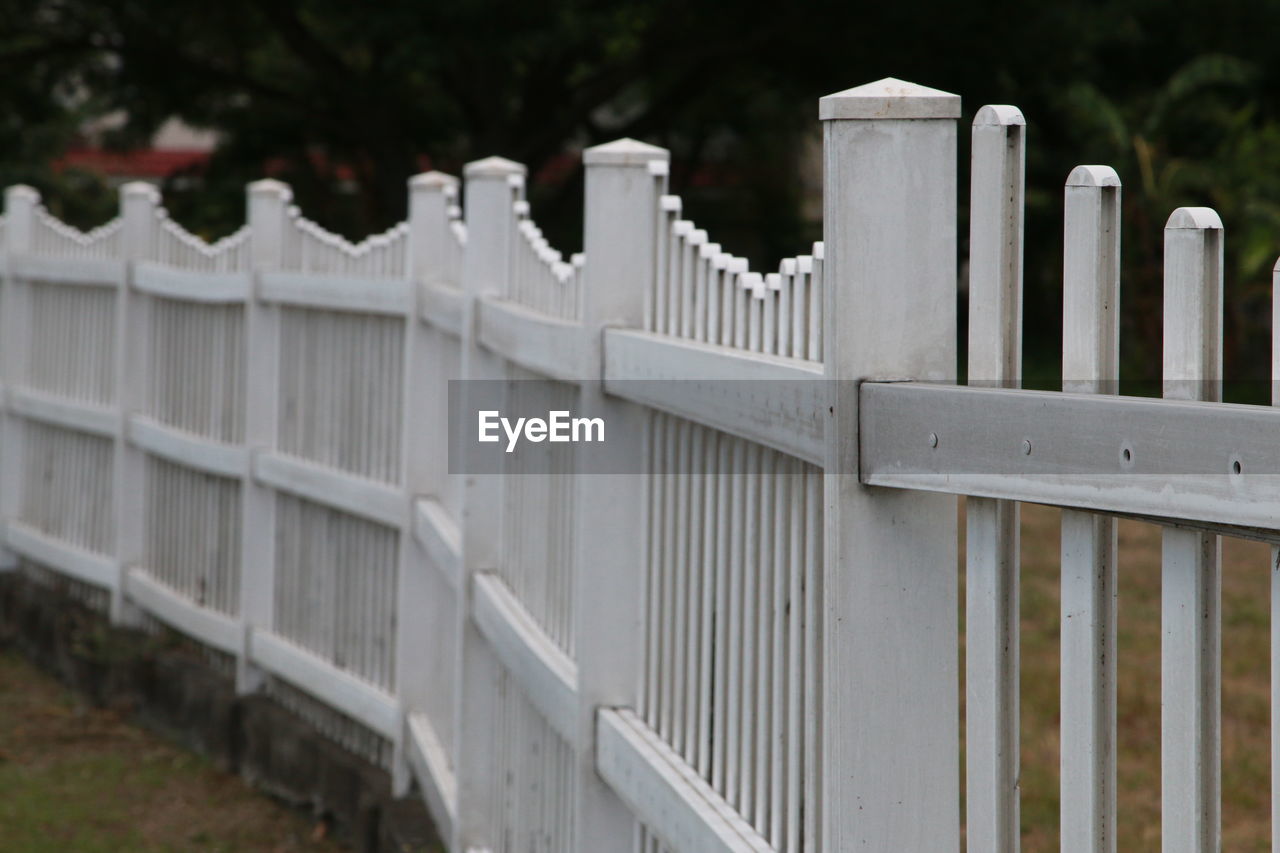 CLOSE-UP OF WHITE FENCE AGAINST WALL