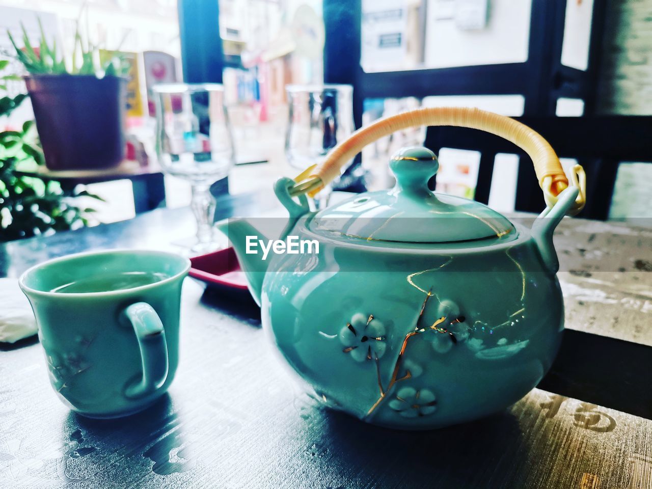 teapot, blue, green, indoors, kettle, tea, table, cup, tableware, tea cup, no people, ceramic, mug, hot drink, art, household equipment, food and drink, drink, domestic room, day, window, still life, focus on foreground, close-up, crockery, nature