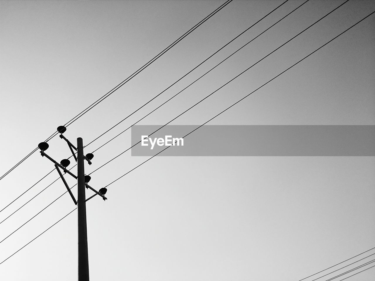 Low angle view of power lines against clear sky