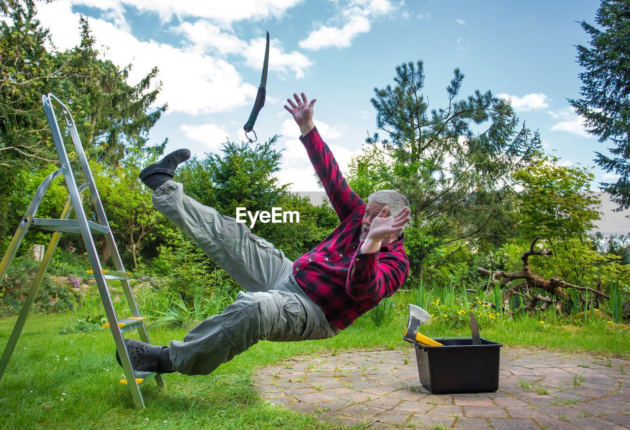 Senior man falling from ladder in garden