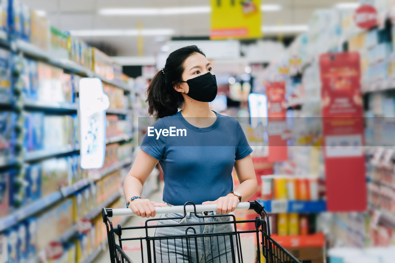 YOUNG WOMAN STANDING IN STORE