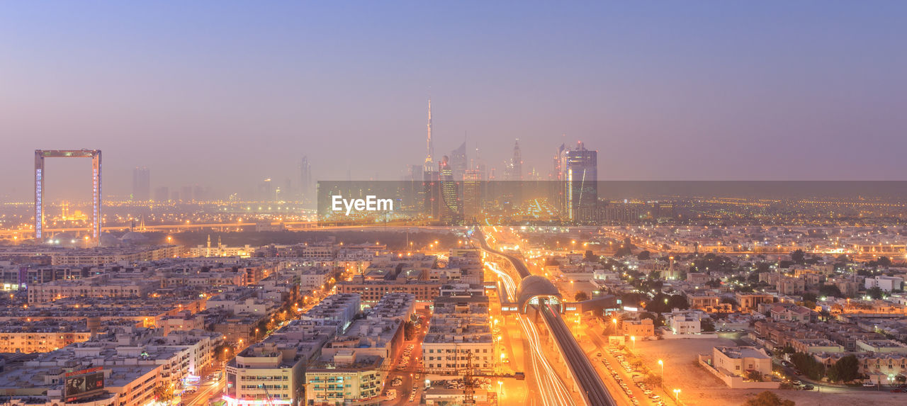 Illuminated cityscape against sky at night