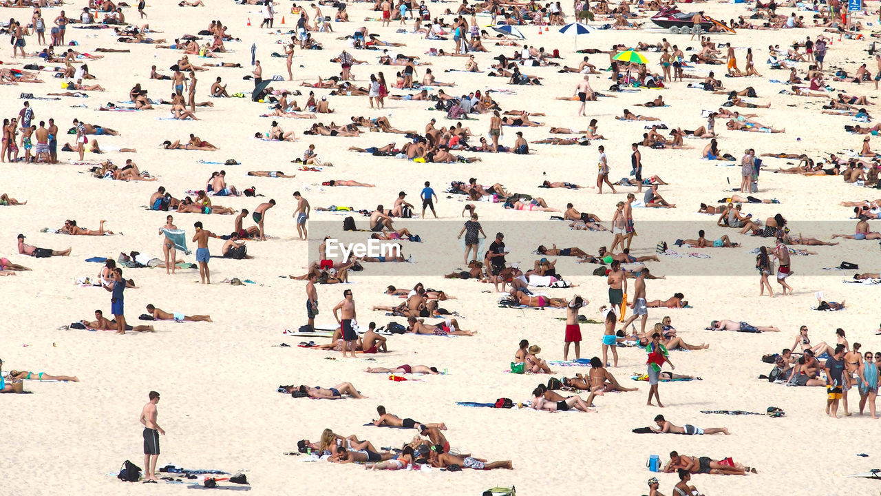 People relaxing on sand at beach