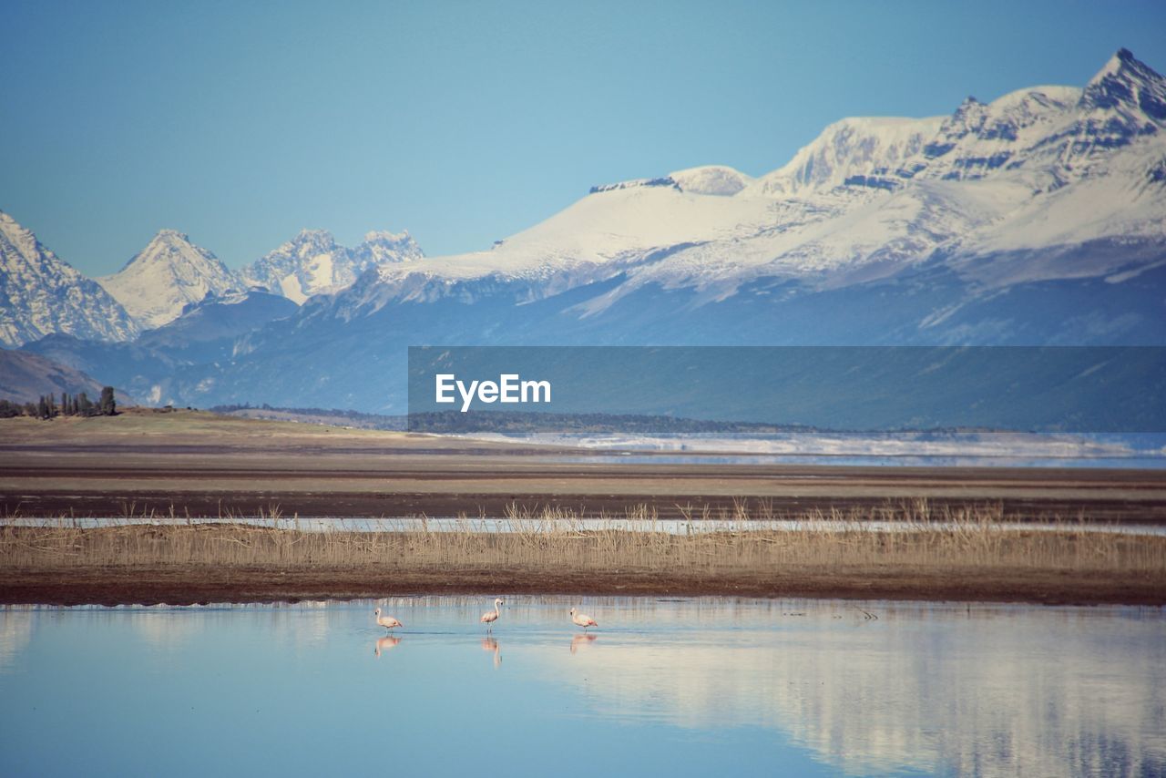 Scenic view of lake and snowcapped mountains against sky