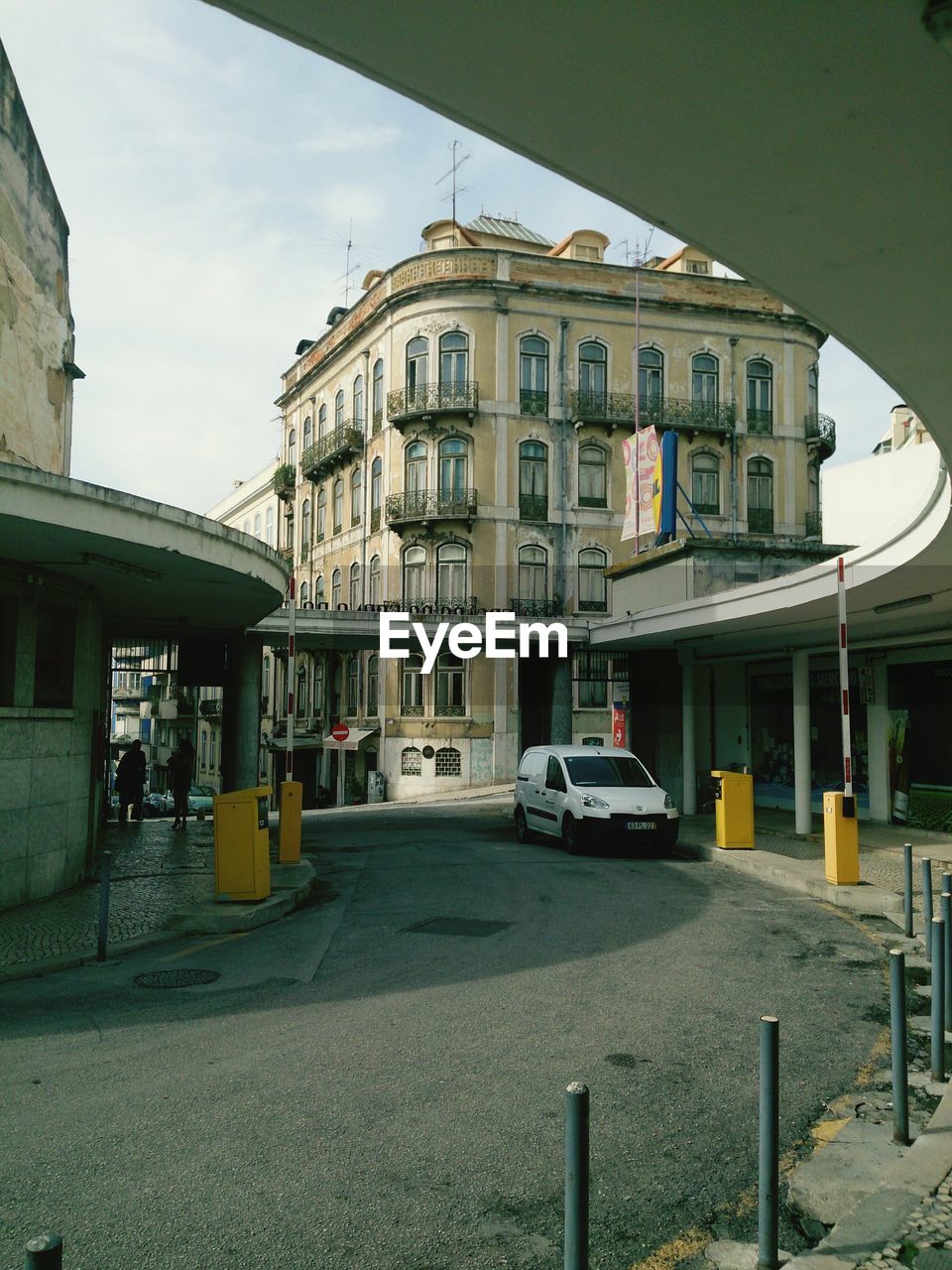 CAR ON STREET IN CITY AGAINST SKY