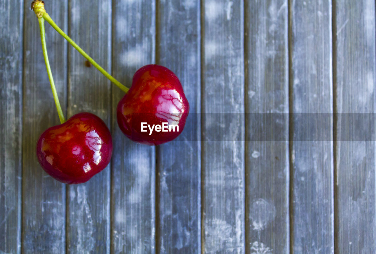 Top view of pair of cherries on rustic background
