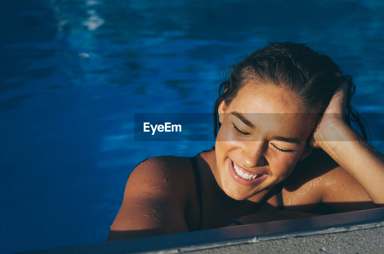 Beautiful smiling young woman in swimming pool
