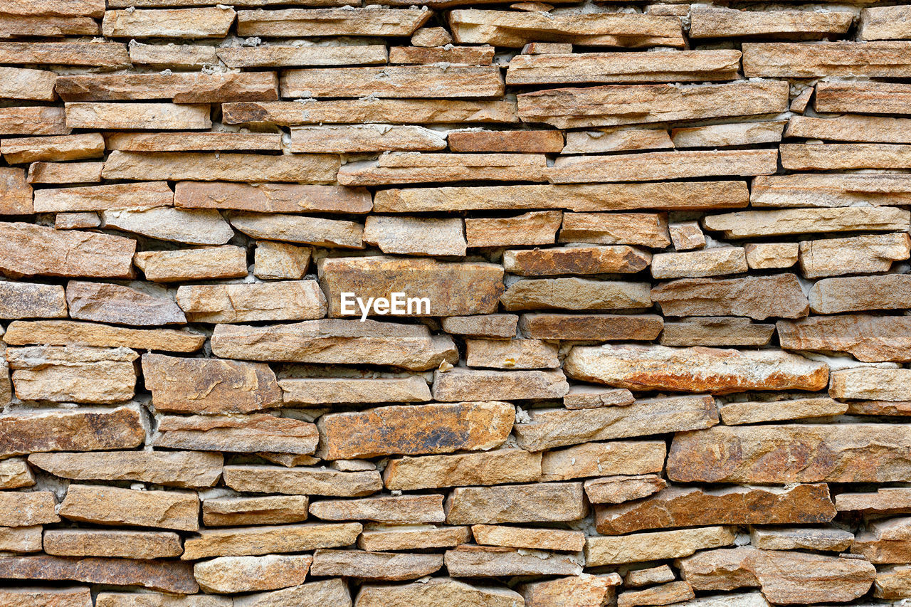 Texture of rough masonry wall from old weathered sandstone.