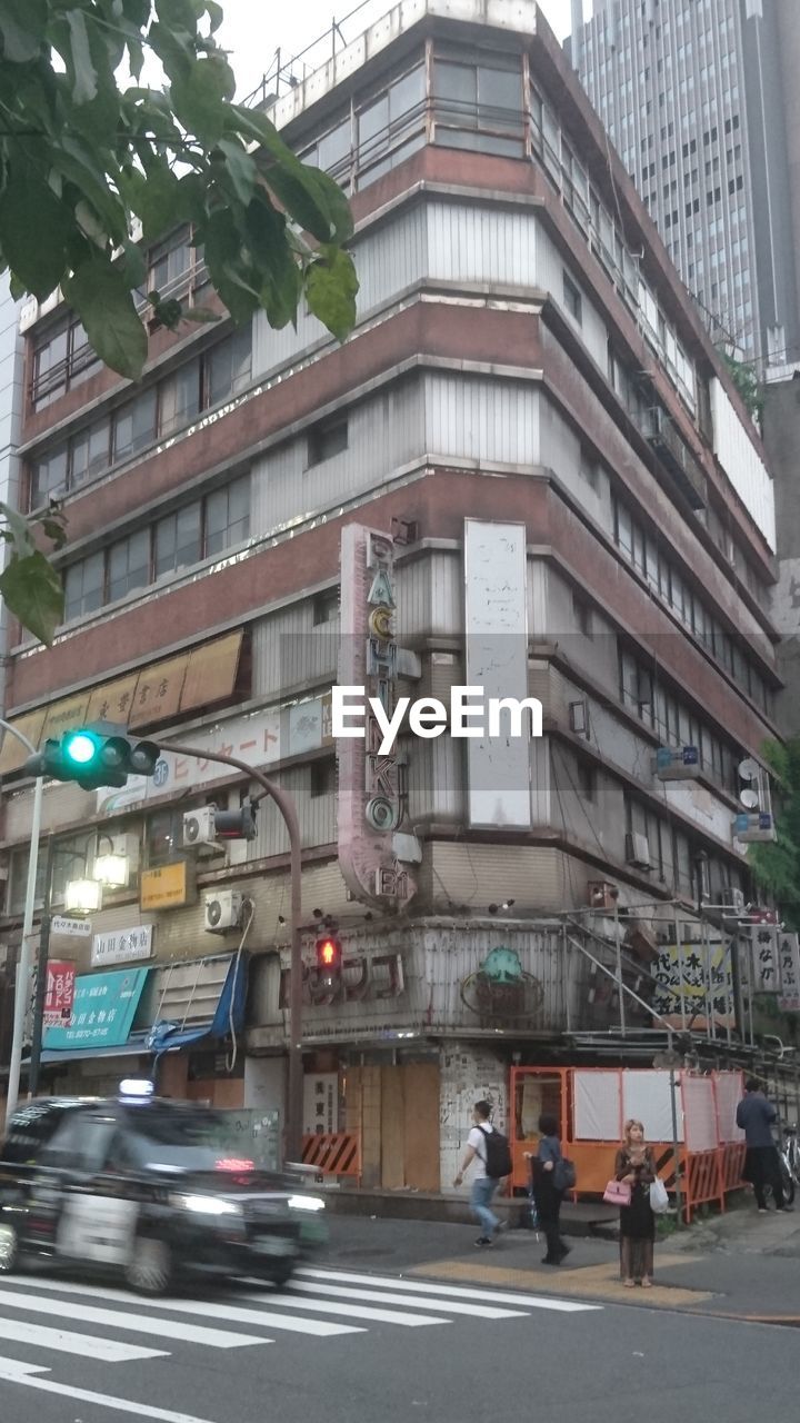 CARS ON ROAD BY BUILDINGS IN CITY