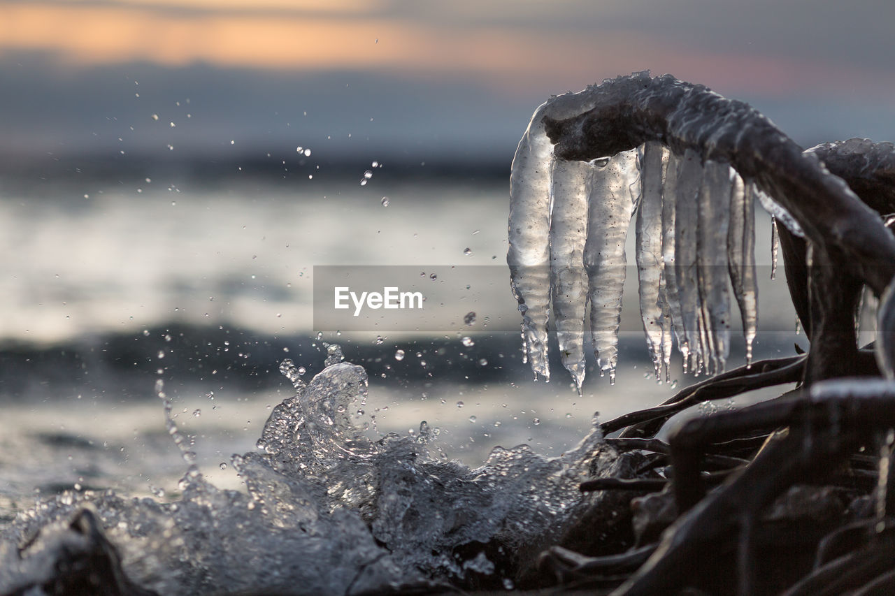 CLOSE-UP OF ICICLES AGAINST SKY