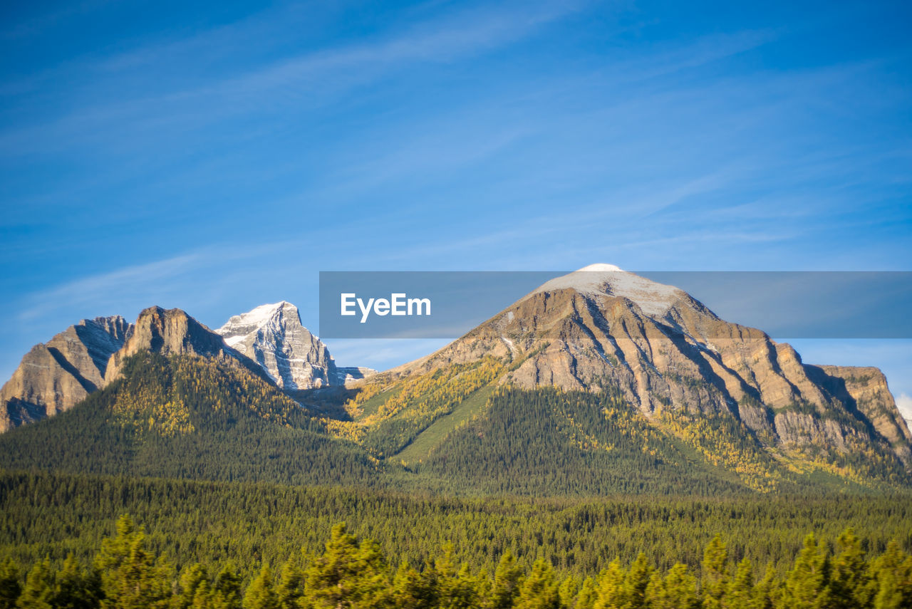 Scenic view of mountains against blue sky