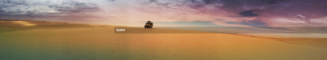 Panoramic view of arid landscape against cloudy sky