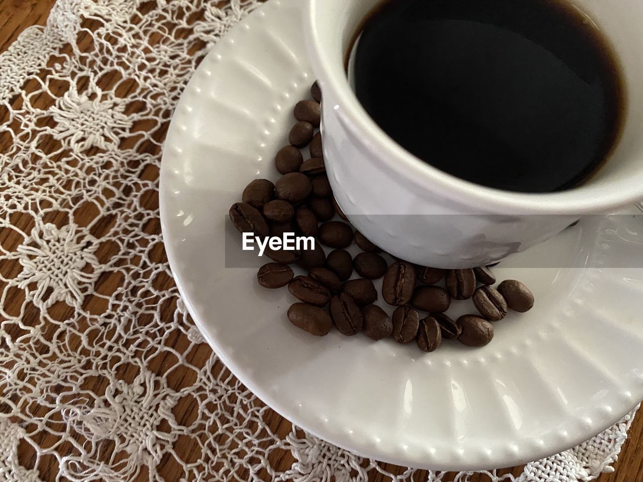 food and drink, cup, coffee, mug, drink, coffee cup, refreshment, food, crockery, black coffee, indoors, table, freshness, saucer, hot drink, high angle view, brown, still life, no people, pattern, close-up, caffè americano, sweet food, tea, tea cup, roasted coffee bean, white