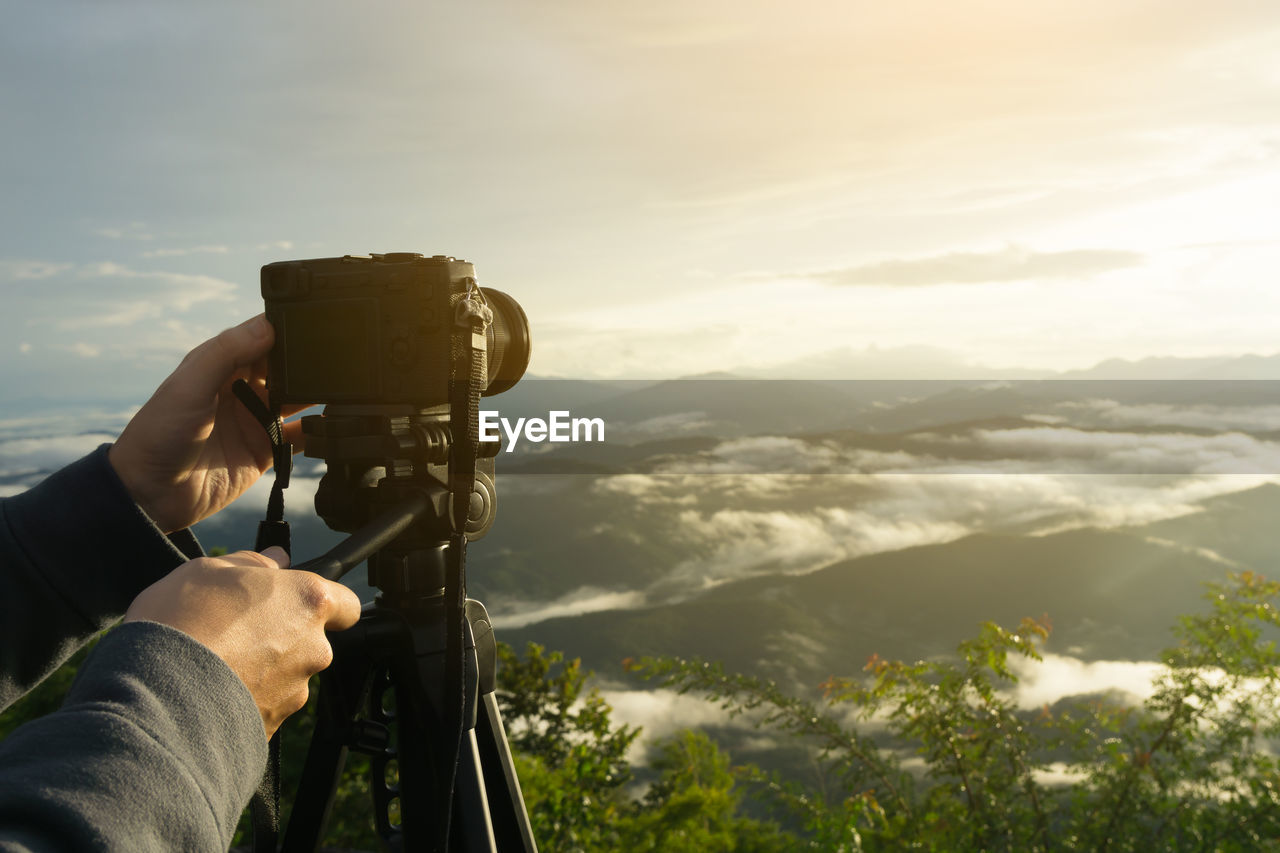 MIDSECTION OF MAN PHOTOGRAPHING AT CAMERA