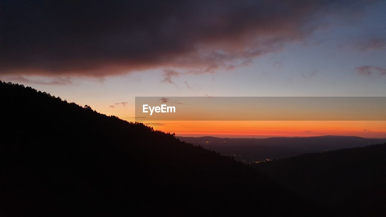 SCENIC VIEW OF SILHOUETTE MOUNTAIN AGAINST DRAMATIC SKY