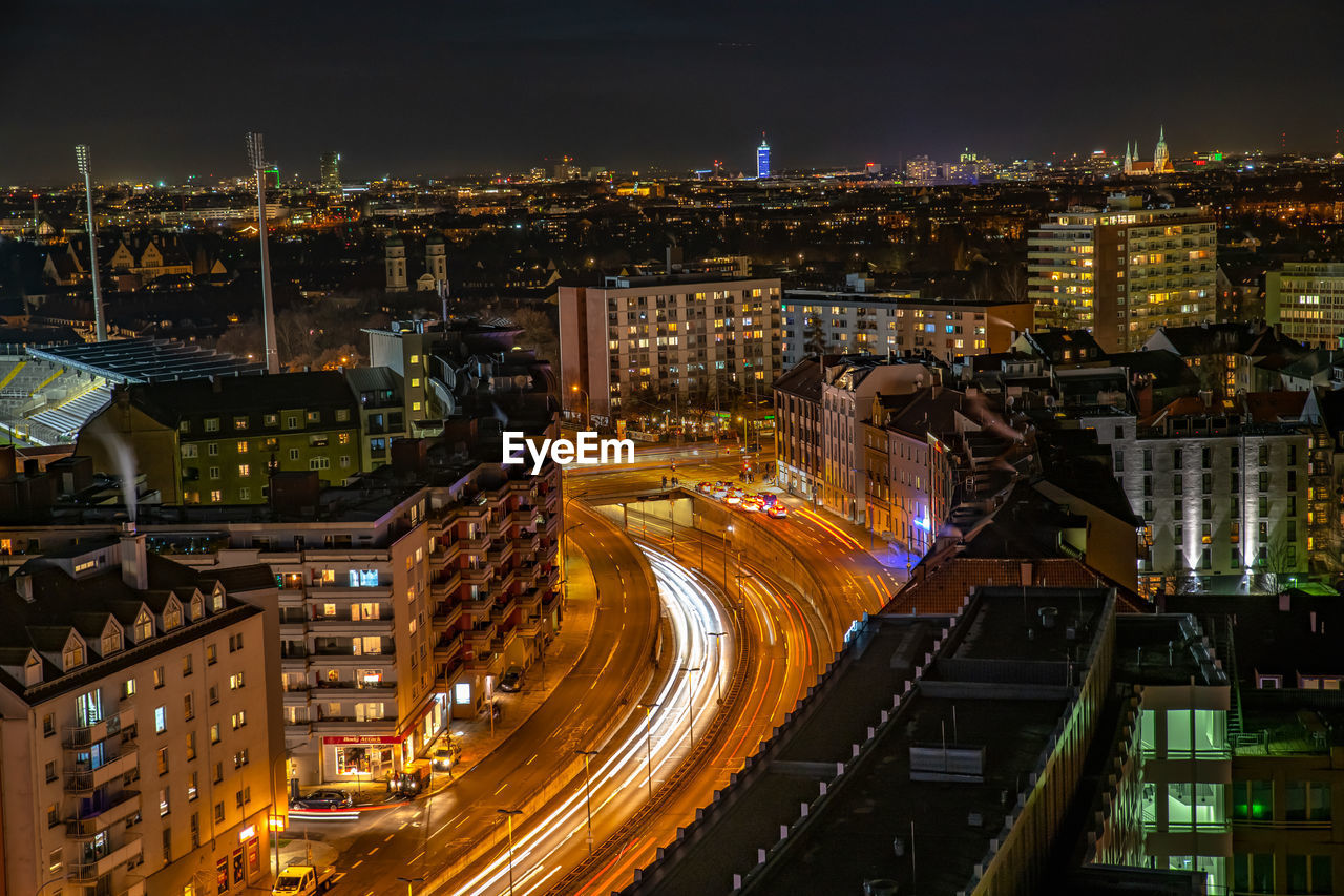 High angle view of illuminated street amidst buildings at night