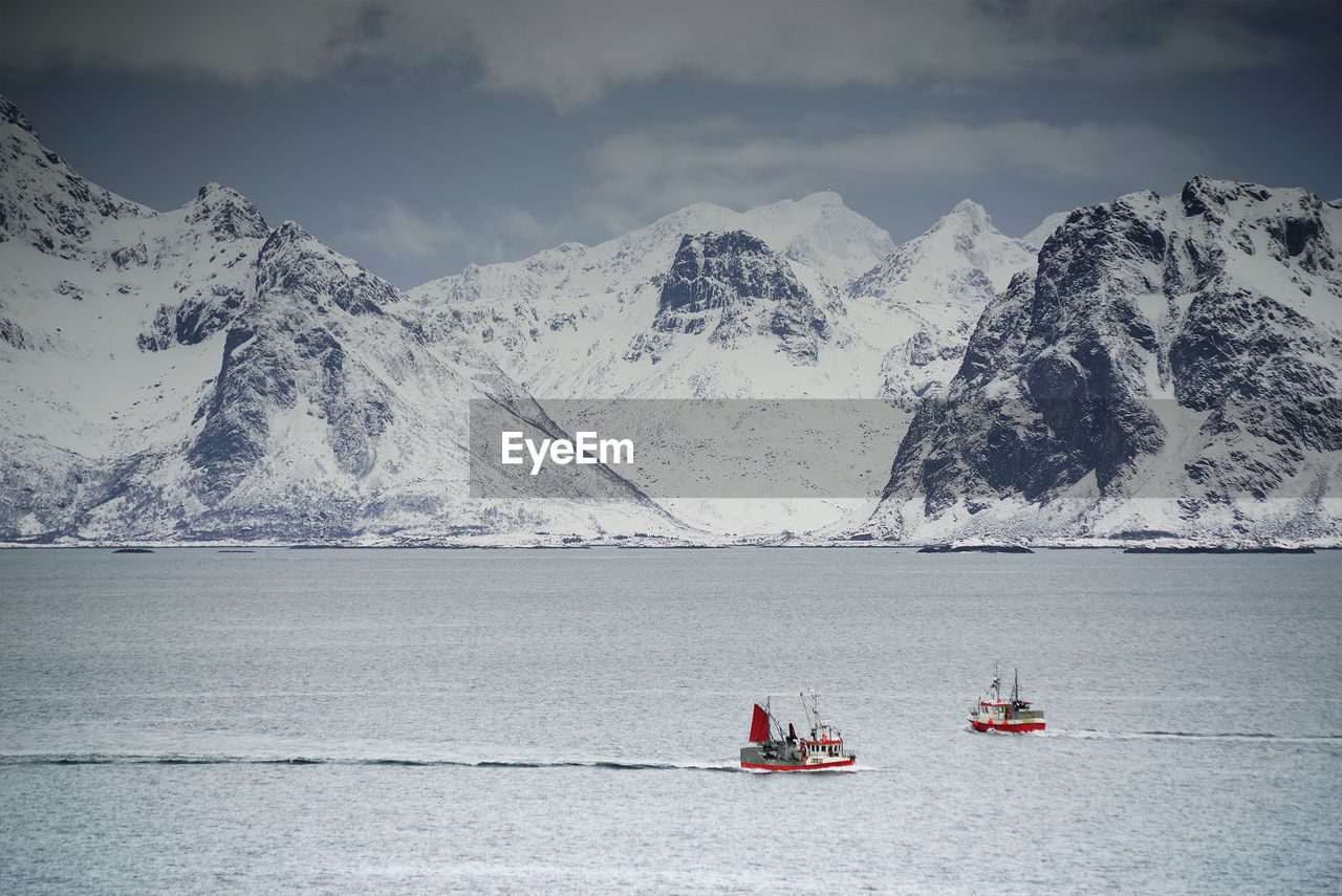 NAUTICAL VESSEL ON SNOWCAPPED MOUNTAINS AGAINST SKY