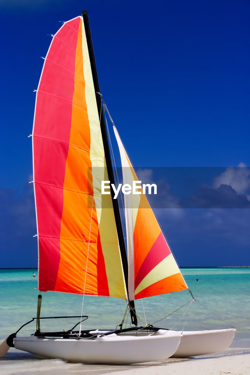 Colorful catamaran on the beach by the caribbean ocean