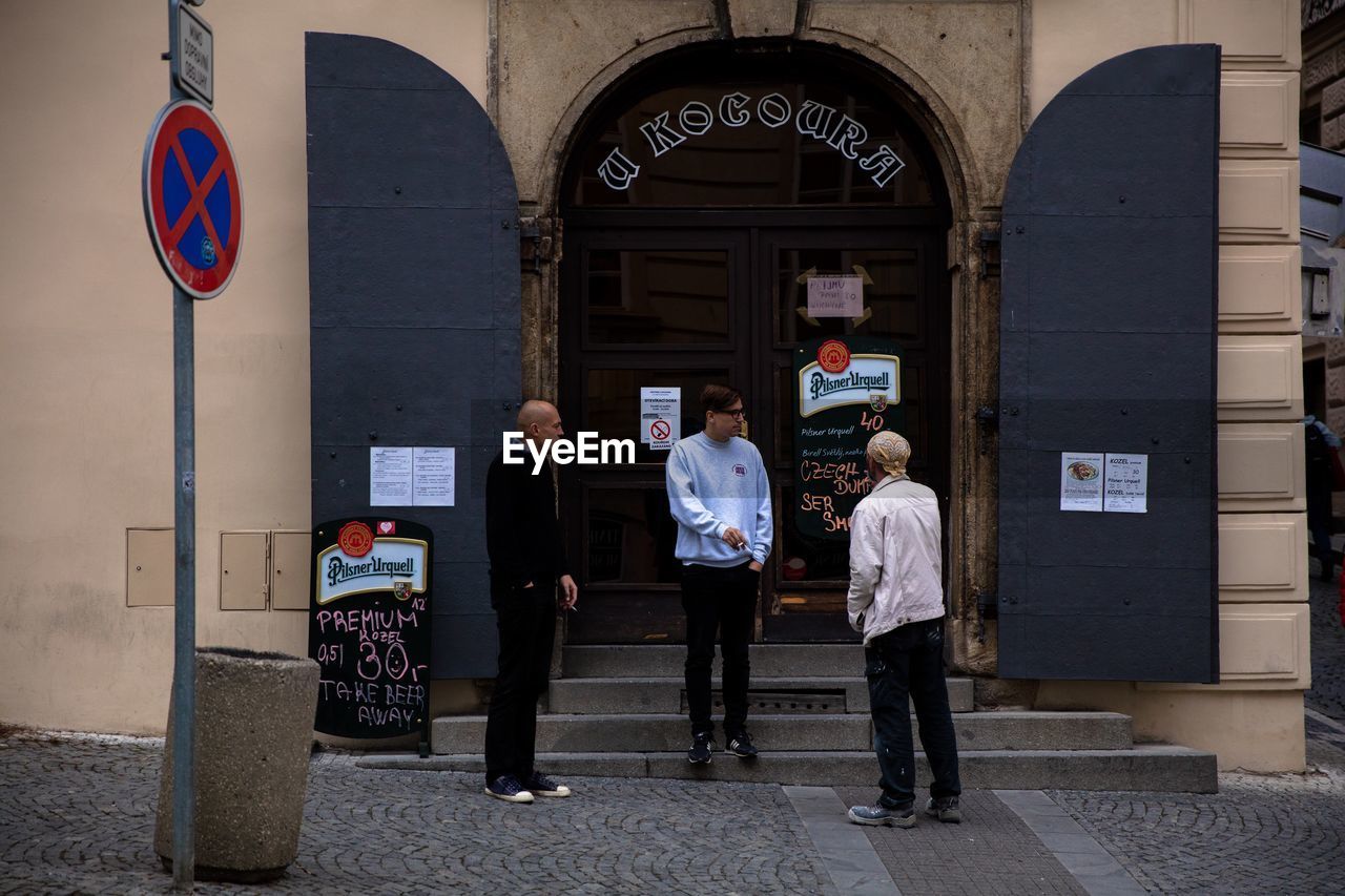 FULL LENGTH OF PEOPLE STANDING IN FRONT OF BUILDING